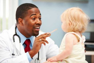 Happy baby being examined by a doctor