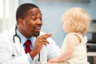Happy baby being examined by a doctor
