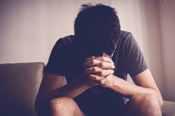 Depressed, despair and anxiety young man sitting alone and praying at home