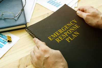 Man opening a disaster and emergency response plan for reading.
