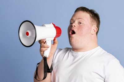 Cute boy with down syndrome using a megaphone to amplify his voice